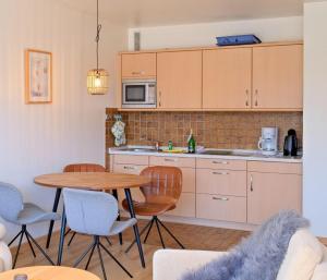 a kitchen with a wooden table and chairs and a table at Germania-36 in Böhl