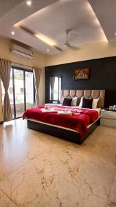 a bedroom with a large bed with a red blanket at Omkar Hotel - Mahabaleshwar in Panchgani +56 photos