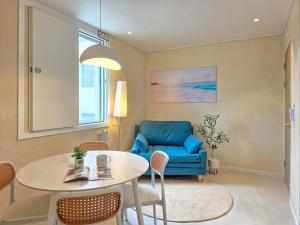 a living room with a table and a blue chair at 스테이동백 in Jeonju