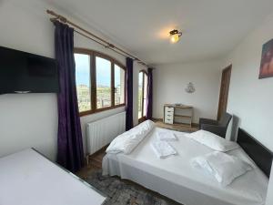 a bedroom with a white bed and a window at Apartaments Doriana in Vama Veche