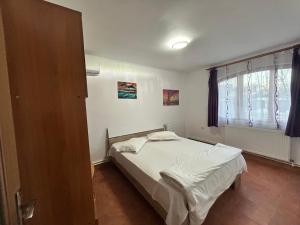 a bedroom with a white bed and a window at Apartaments Doriana in Vama Veche