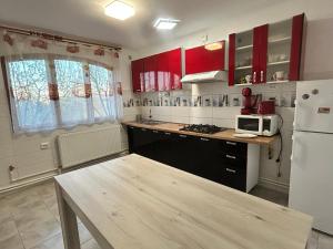 a kitchen with red cabinets and a white refrigerator at Apartaments Doriana in Vama Veche