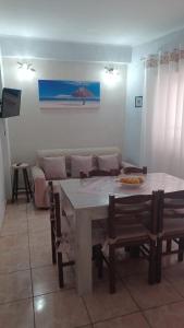 a dining room with a table and chairs and a couch at Perla del mare Ionio in Fondachello