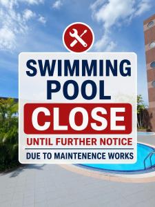 a swimming pool closed sign in front of a pool at Beta Service Apartment in Labuan