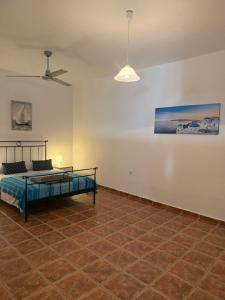 a bedroom with a bed and a ceiling fan at Villa Aphrodite in Koundouros
