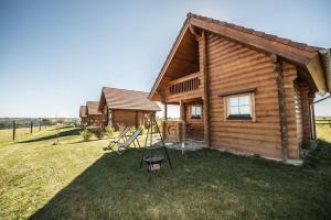 une cabane en rondins avec une table et des chaises en face de celle-ci dans l'établissement Ranch des bisons, à Petit-Réderching