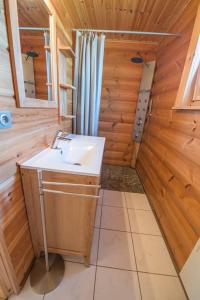 - une salle de bains pourvue d'un lavabo dans une cabine en bois dans l'établissement Ranch des bisons, à Petit-Réderching