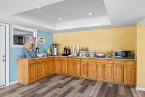 a kitchen with wooden cabinets and a counter top at Super 8 by Wyndham Acworth/Atlanta Area in Acworth