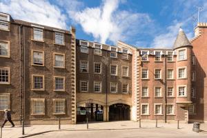 a large brick building with a man walking past it at The Wee Thistle in Edinburgh