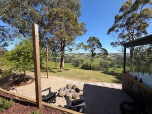 a patio with a group of rocks and a pole at Stylish 2-Bed Home, Stunning View, Fire Pit, Festoon Lights, BBQ and walk to Pub in Poowong