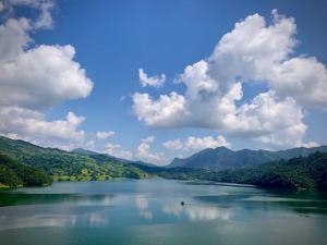 a view of a lake with mountains in the background at Hotel crunchy shadowbegnas in Deorāli +4 photos