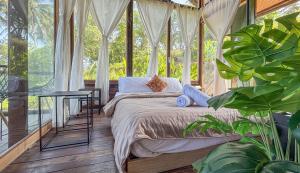 a bedroom with a bed in a glass house at Salty Cabin Sunset Views Yeh Leh Beach in Balian +67 photos