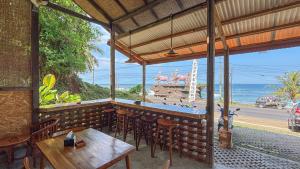 a restaurant with a bar with a view of the ocean at Salty Cabin Sunset Views Yeh Leh Beach in Balian