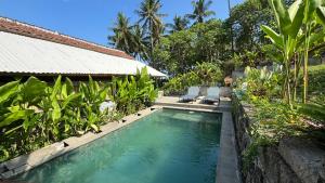 a swimming pool in front of a house at Salty Cabin Sunset Views Yeh Leh Beach in Balian