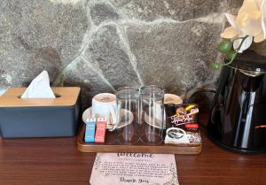 a wooden tray with glasses and a vase on a table at Salty Cabin Sunset Views Yeh Leh Beach in Balian