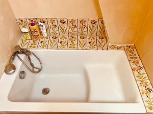 a white bath tub in a bathroom with tiles at Ecurie Piaffe & Cie in Lurais