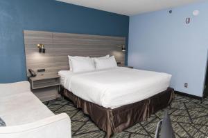 a large bed in a room with a blue wall at Wingate by Wyndham North Little Rock in North Little Rock +50 photos