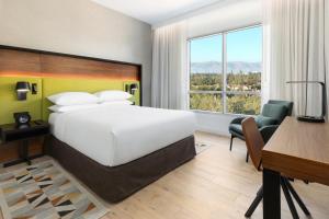a hotel room with a large bed and a desk and a desk at Hyatt Centric Mountain View in Mountain View