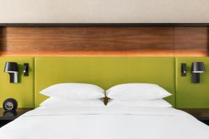 a bedroom with a white bed with a green headboard at Hyatt Centric Mountain View in Mountain View
