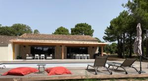 a villa with a swimming pool and two chairs and a house at Villa Casa di sognu in Lecci