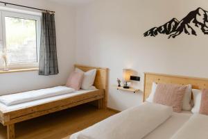 a bedroom with two beds and a window at Ferienwohnung Enzian in Halblech