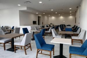a waiting room with tables and blue chairs at Wyndham Puebla Angelopolis in Puebla