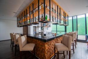a restaurant with a bar with chairs and a chandelier at Wyndham Puebla Angelopolis in Puebla