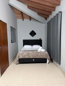 a bedroom with a bed with a black headboard at Pousada Akros in Asunción +38 photos