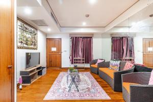 a living room with a couch and a tv at 2BR Duplex in central Chitlom in Bangkok
