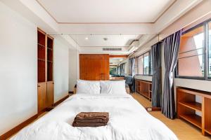 a bedroom with a bed with a bag on it at 2BR Duplex in central Chitlom in Bangkok