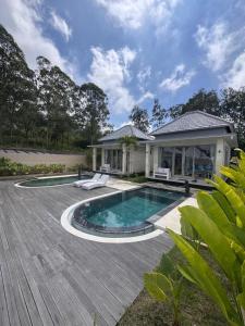 a home with a swimming pool and a house at The Breezy Volcano in Kintamani
