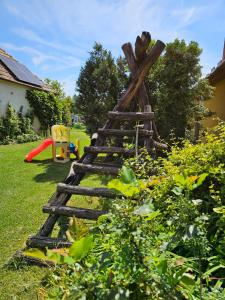 a wooden ladder in the grass in a yard at Ágnes Apartmanok in Harkány