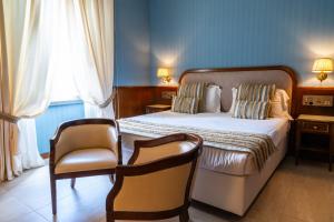a bedroom with a bed and a chair and a couch at Grand Hotel Bastiani in Grosseto +27 photos
