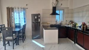 a kitchen with a refrigerator and a table with chairs at Vedavit Bhavanam in Gaya +8 photos