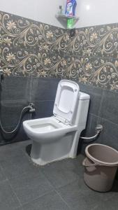 a bathroom with a toilet and a wall at Vedavit Bhavanam in Gaya