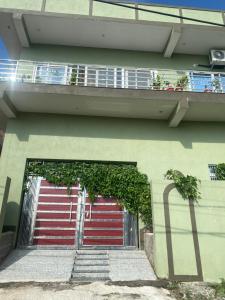 a building with a red garage door with a balcony at Vedavit Bhavanam in Gaya