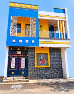 a building with blue and yellow doors and a balcony at La Baie Homestay in Pondicherry