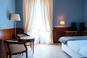 a hotel room with a bed and a table and chairs at Grand Hotel Bastiani in Grosseto
