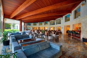 a lobby with couches and chairs and a restaurant at Sealight Resort Hotel in Kuşadası
