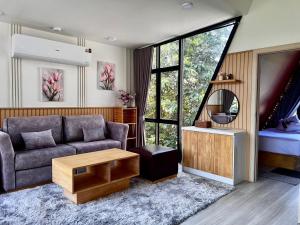a living room with a couch and a mirror at ฟูจิจันท์ fujijun cafe&resort in Ban Na Khieo +107 photos