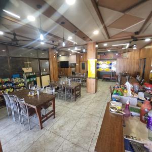 a restaurant with tables and chairs in a room at Hotel Anmol&Rooms in Gothaj