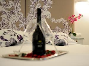 Easyrome Guest House في روما: زجاجة من النبيذ موضوعة فوق السرير