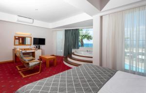 a hotel room with a bed and a bath tub at Sealight Resort Hotel in Kuşadası
