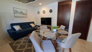 a living room with a table and a blue couch at Villas Boutique Casa Ricarda in Aticama