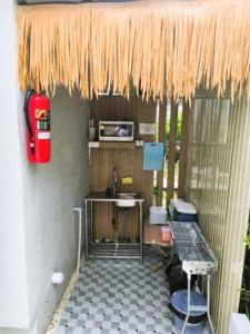 a kitchen with a table under a straw roof at 7 Class Pool Villa in Chachoengsao