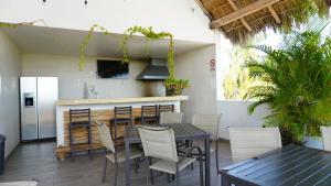 a patio with a table and chairs and a refrigerator at Villas Boutique Casa Ricarda in Aticama