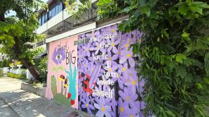a wall with graffiti on it next to a tree at Hotel Bella Monte in Olongapo