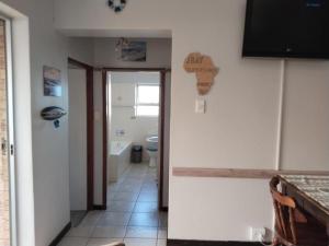 a room with a bathroom with a toilet and a hallway at The Deck in Jeffreys Bay