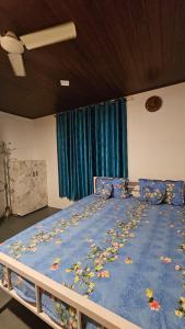 ein Bett mit einer blauen Decke mit Blättern darauf in der Unterkunft Bambooleaf pool dormitory in Meppādi + 35 Fotos