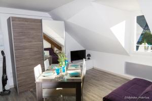 a dining room with a table and a tv at Le Sancy in Le Mont-Dore